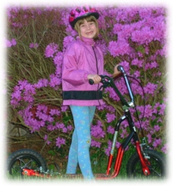 Diana standing on scooter in front of azalea bush